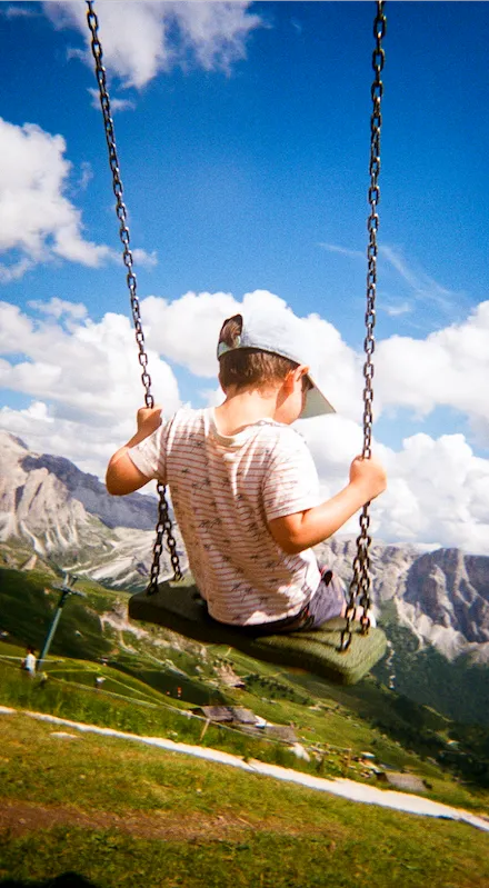 Victor sur une balancoire à l'l'Alpe di Siusi